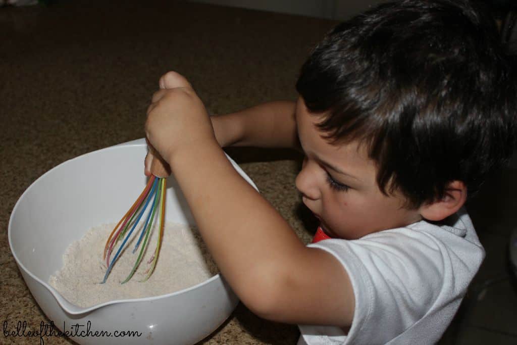 a boy stirring ingredients in a bowl