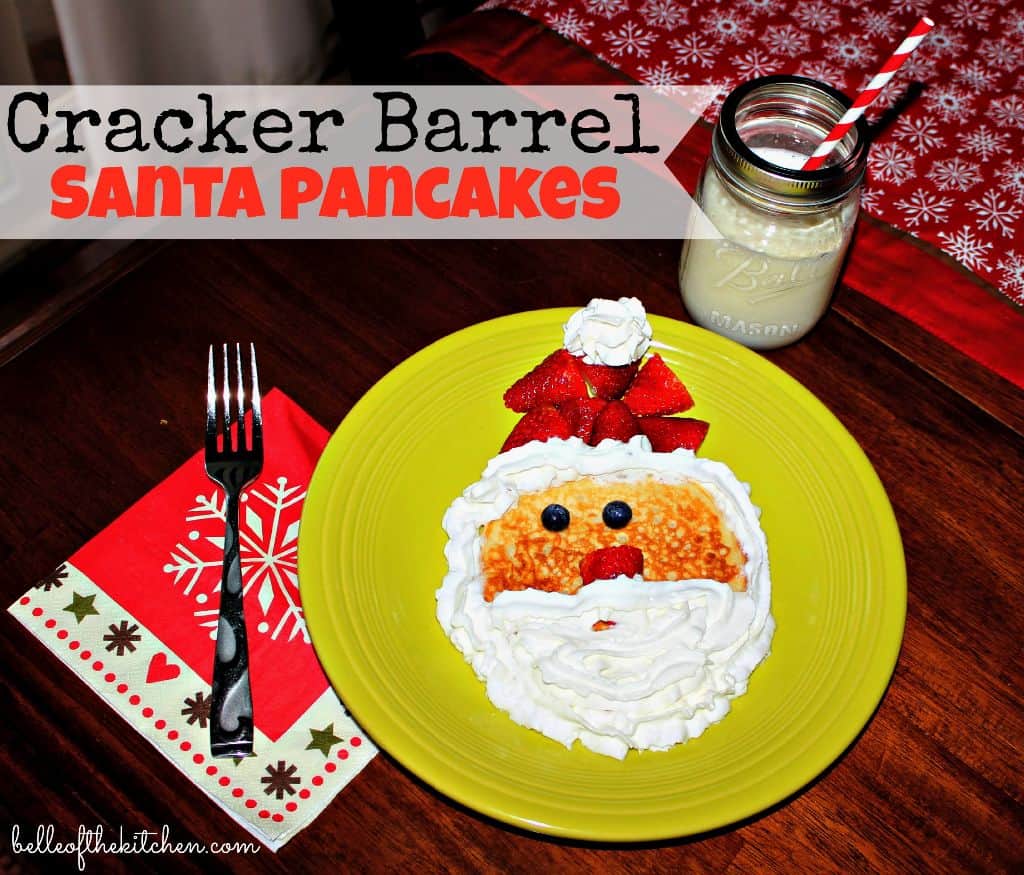 A plate with pancakes that look like Santa with fruit and whipped cream