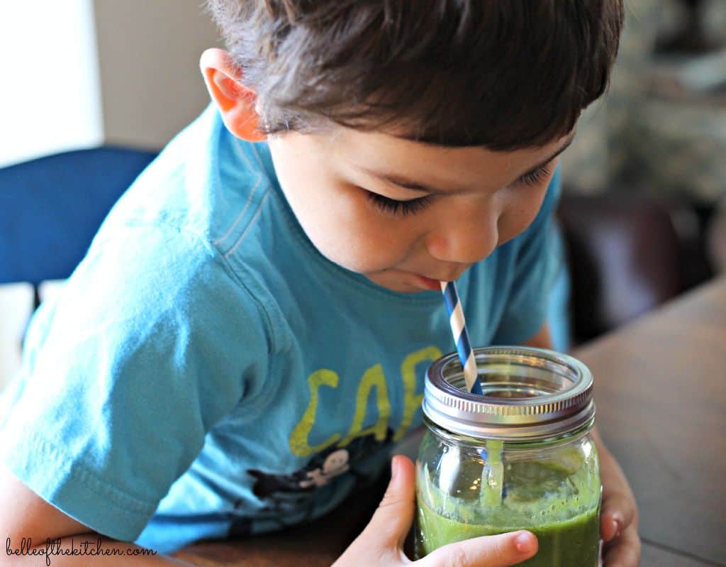 A little boy drinking a smoothie