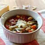 A bowl of soup with beans and sausage
