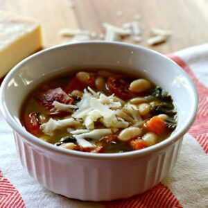 A bowl of soup with beans and sausage