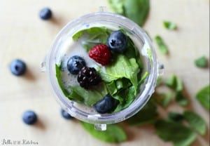 A cup filled with berries and spinach