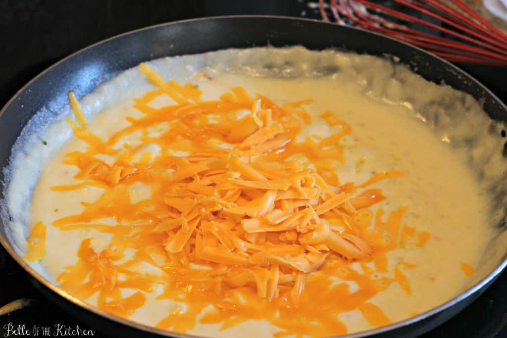 a pan full of sauce and shredded cheese