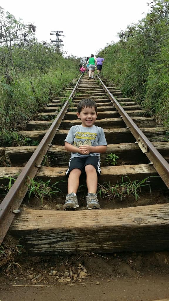 A little boy sitting on wooden stairs