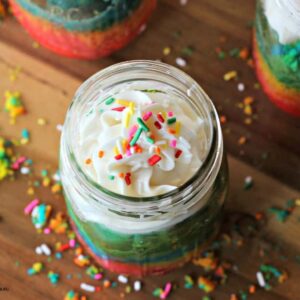 cake in a jar with frosting on top and sprinkles