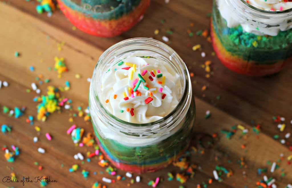 cake in a jar with frosting on top and sprinkles