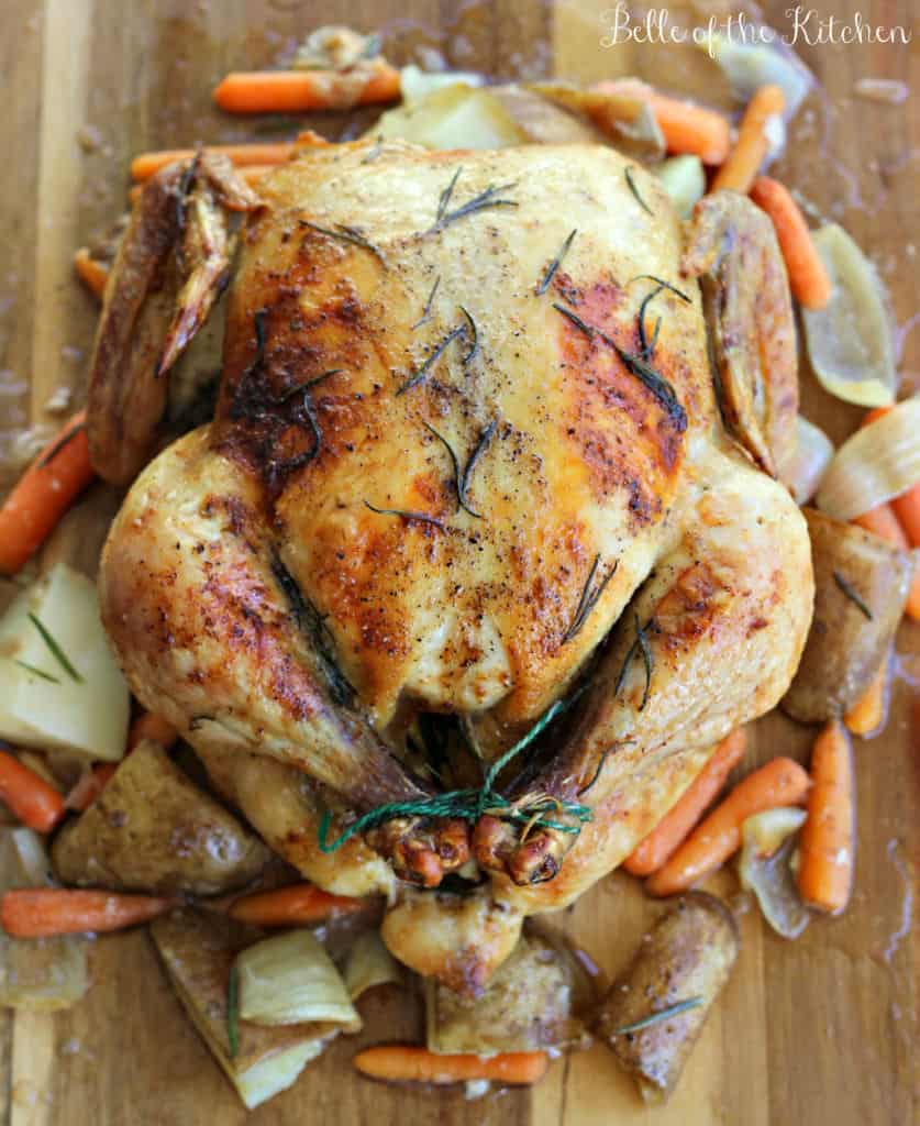 a roasted whole chicken with veggies on the side