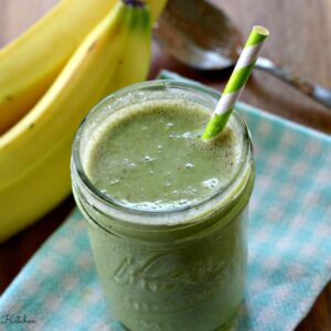 a green smoothie in a jar with a straw