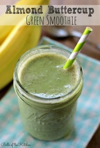 A mason jar filled with a green smoothie and a banana in the background