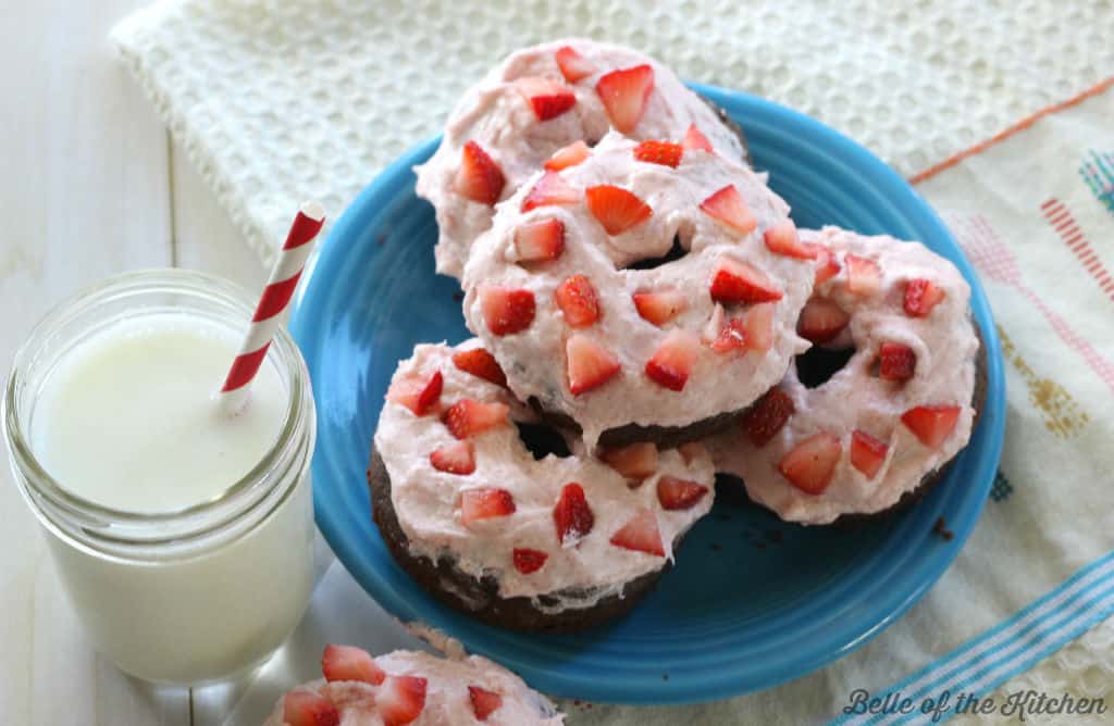 A close up of a donut with strawberries on top