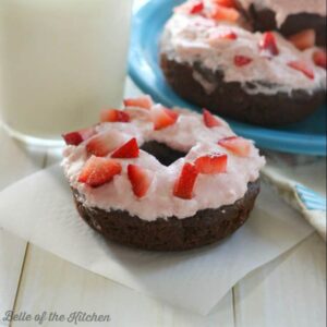 A close up of a donut with strawberries on top