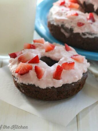 A close up of a donut with strawberries on top