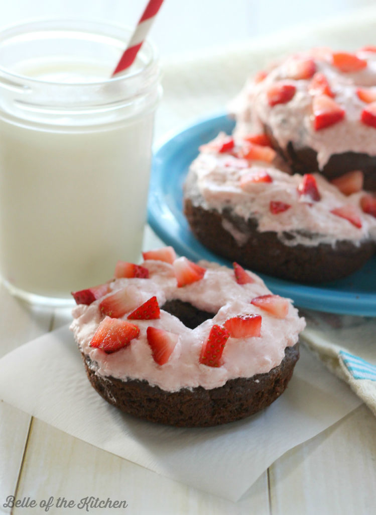 A close up of a donut with strawberries on top