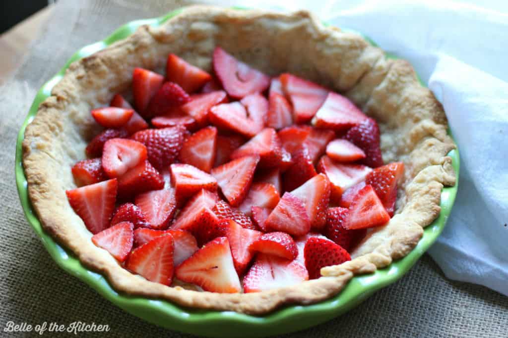 a pie crust full of sliced strawberries