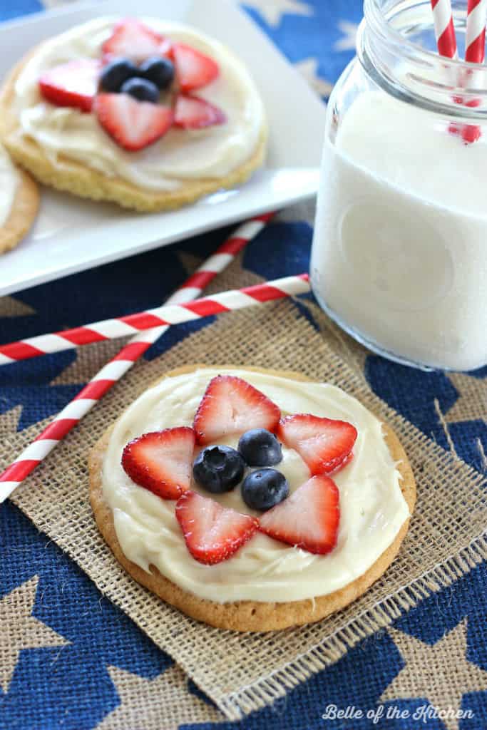 mini fruit pizzas on a burlap background with a glass of milk