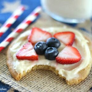 A close up of a cookie with fruit on top and a bite taken out