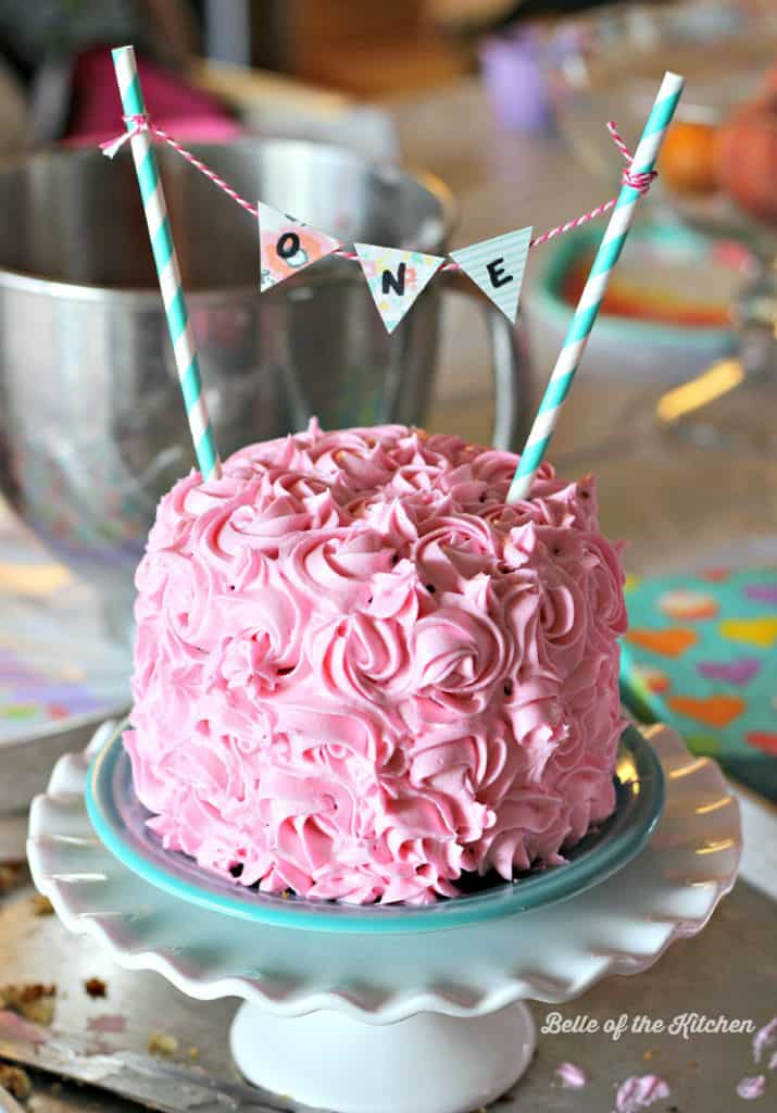 A plate with a pink frosted birthday cake