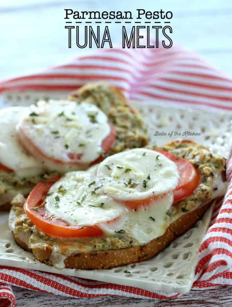 A tuna melt with tomatoes on top of a white plate