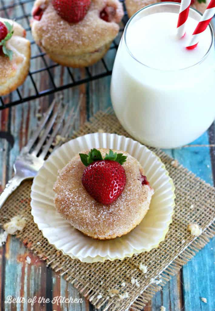 a muffin with strawberries beside it, wrapped in string