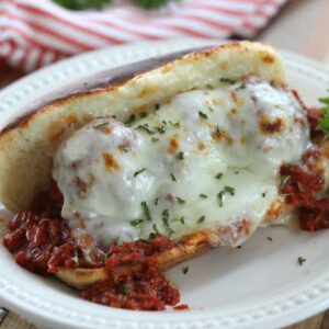 A plate with a meatball sandwich on it