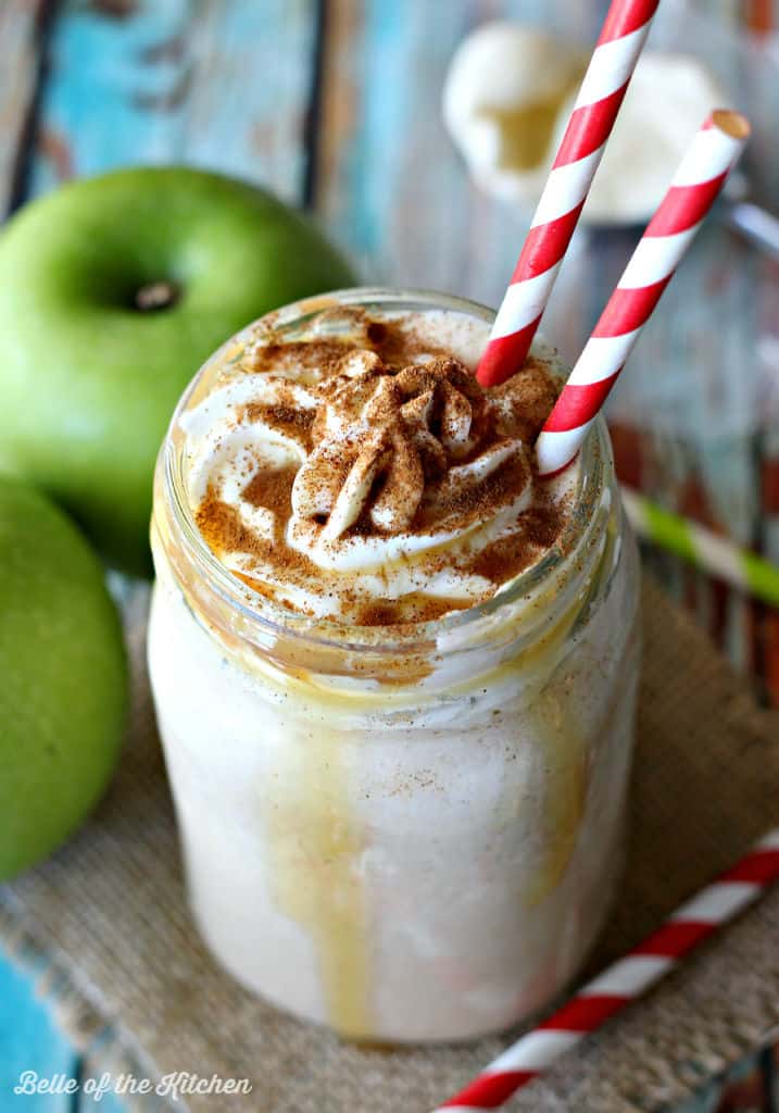 a milkshake beside green apples