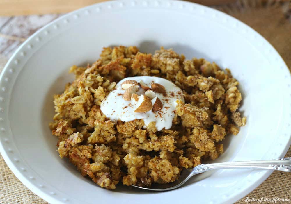 A bowl of oatmeal topped with yogurt and chopped nuts