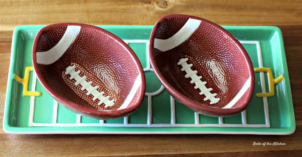 two football shaped bowls on a green plate