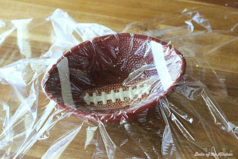 a football shaped bowl filled with plastic wrap