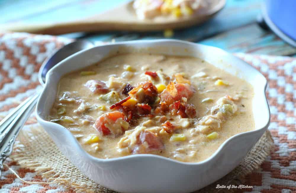 A white bowl full of soup topped with bacon