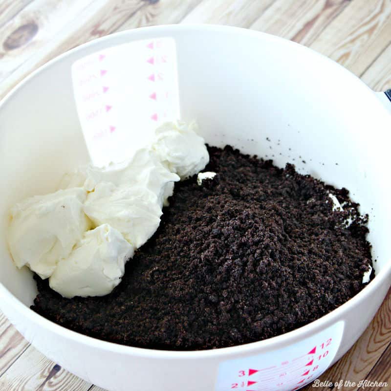 A close up of bowl of crushed Oreos and cream cheese