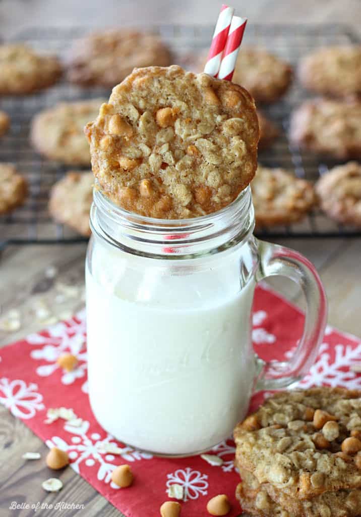 A glass of milk with an oatmeal cookie on top