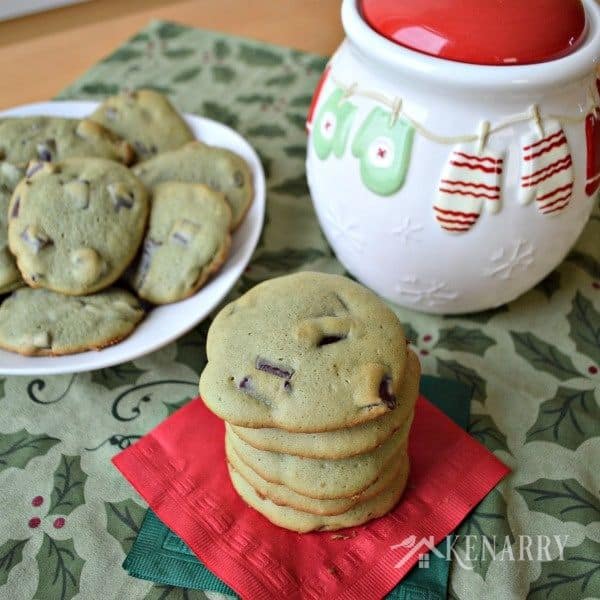 a stack of chocolate chunk cookies beside a plate 