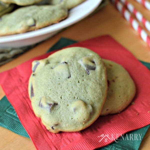 a stack of chocolate chunk cookies beside a plate 