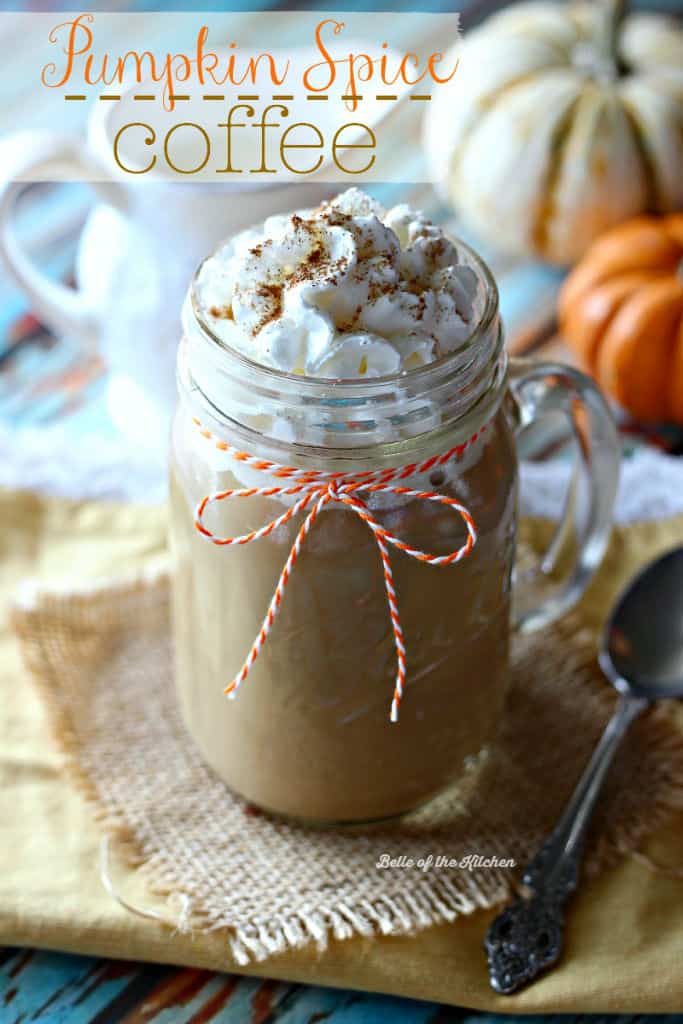 A mug filled with coffee and whipped cream wrapped in an orange piece of string