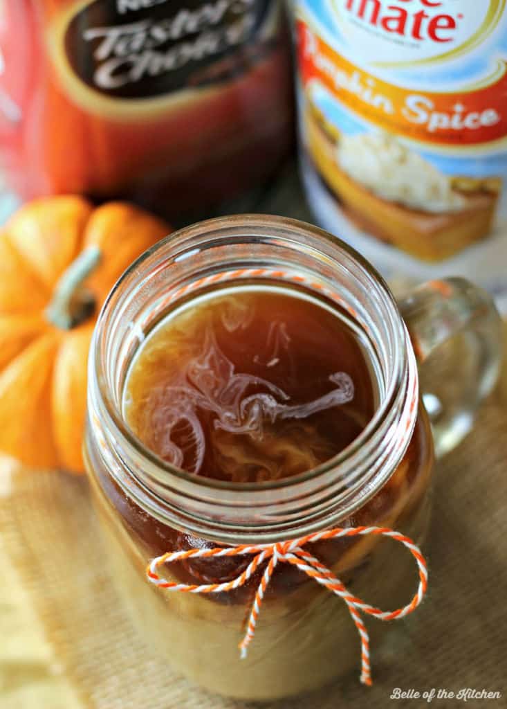 A mug filled with coffee wrapped in an orange piece of string