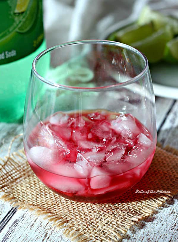 A close up of a wine glass with limeade and ice