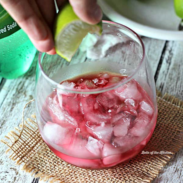 A close up of a wine glass with limeade and ice