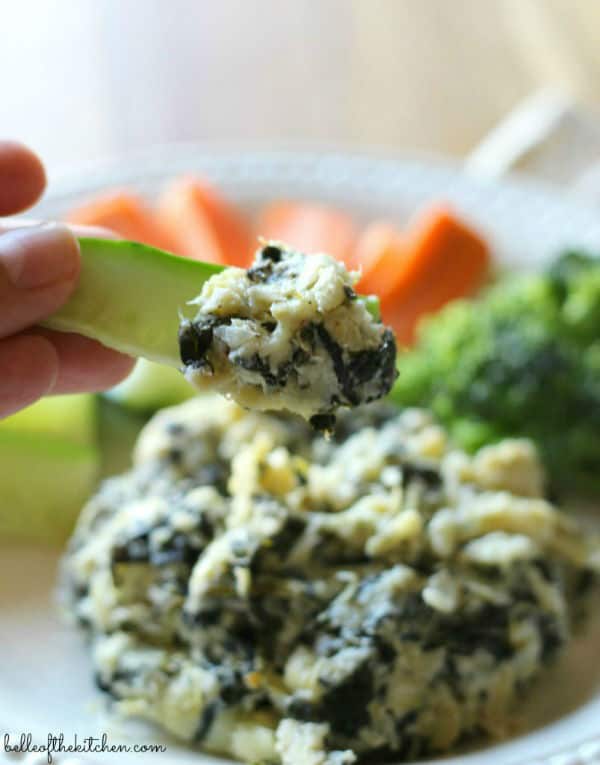 A close up of a plate of food with artichoke dip and vegetables