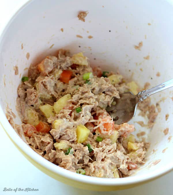 A bowl of tuna salad mixed with pineapple and tomatoes