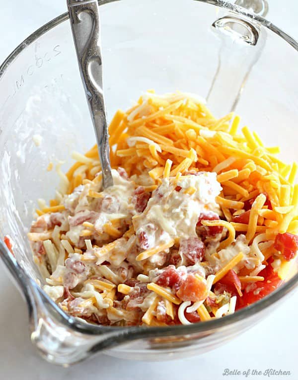 A bowl of cheese, mayonnaise, and tomatoes