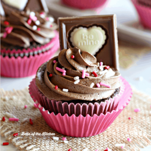 A chocolate cupcake topped with sprinkles and a chocolate bar