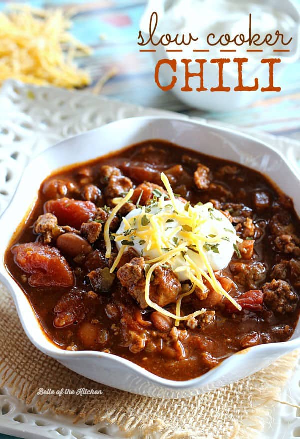 A bowl of chili topped with sour cream and shredded cheese