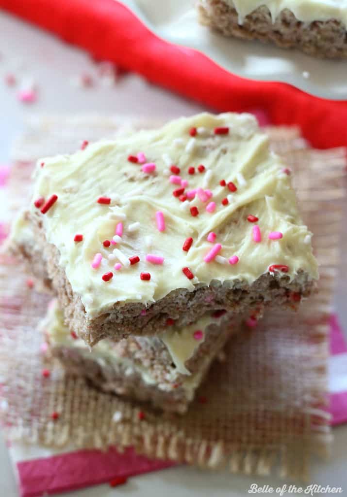 a stack of Rice Krispie treats topped with frosting and pink sprinkles