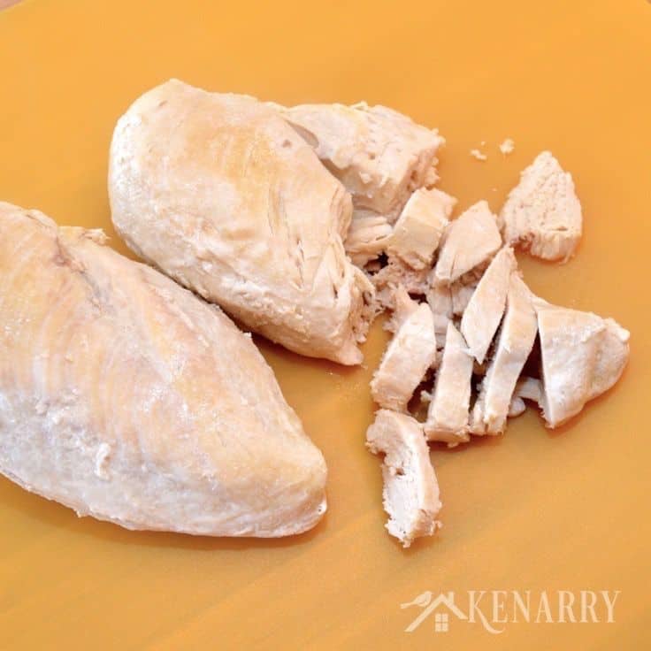 two cooked chicken breasts being sliced