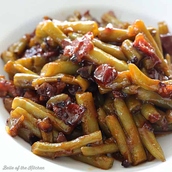 A plate of green beans with bacon and bbq sauce