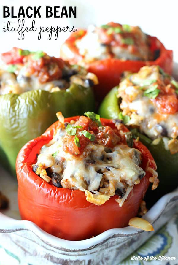 A dish is filled with peppers stuffed with a rice filling and topped with salsa and cilantro