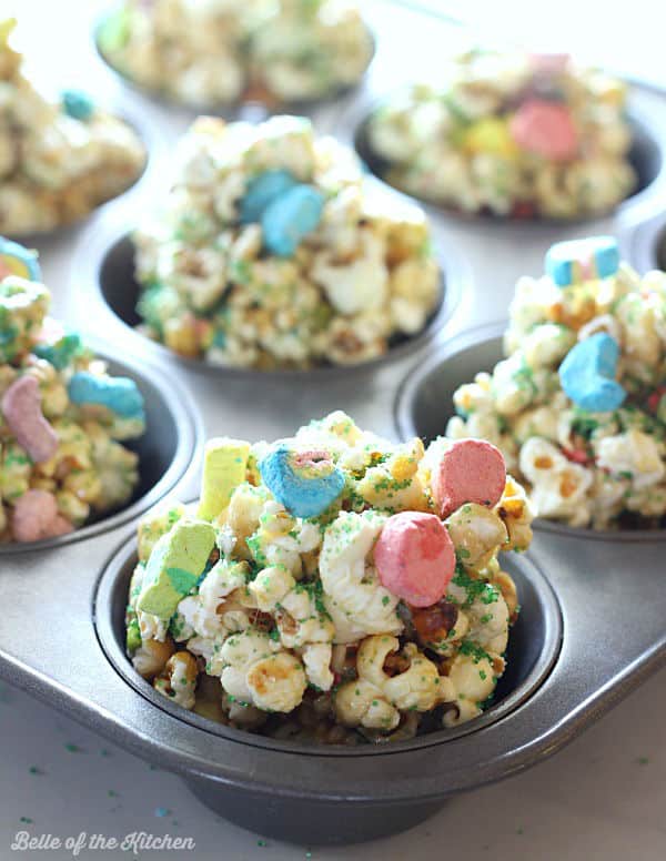 popcorn balls in muffin cups topped with lucky charms marshmallows