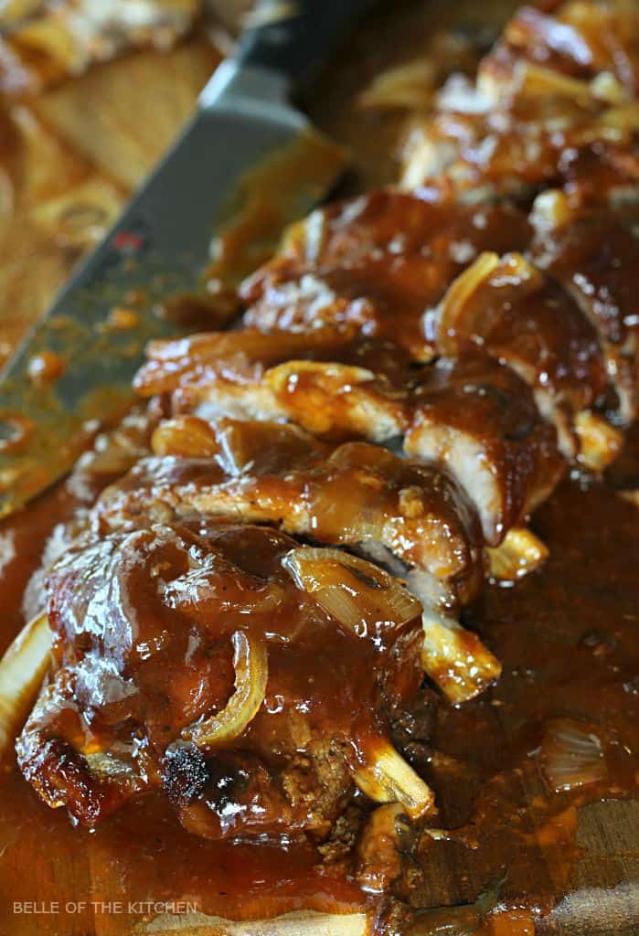 A close up of ribs and onions on a cutting board