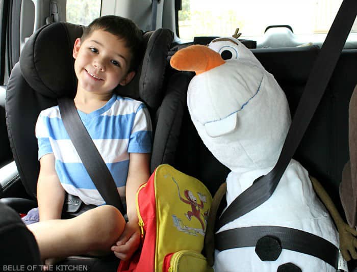 A little boy sitting a stuffed snowman