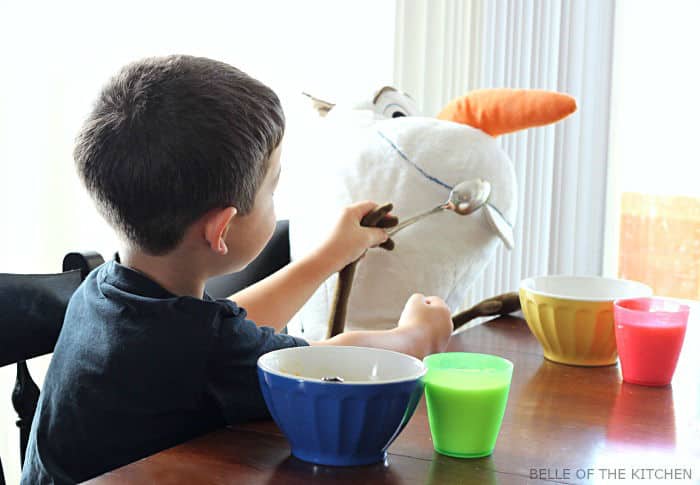a boy feeding a stuffed animal